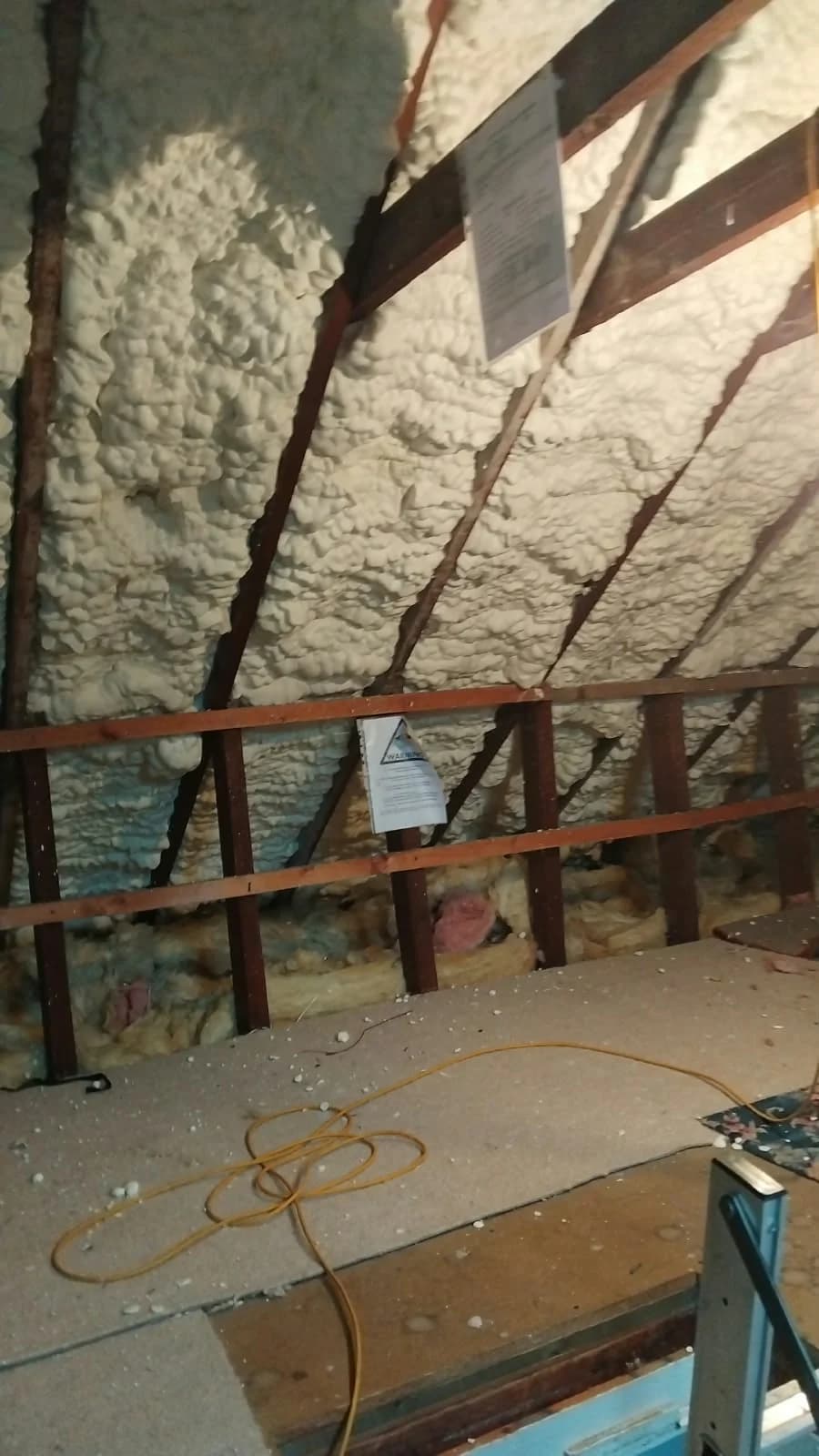 Spray foam between roof timbers before removal at a home in Dalry, North Ayrshire