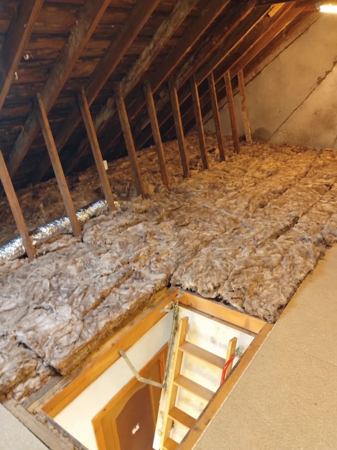 Completed Kilwinning loft with new mineral wool insulation and boarding beside the loft hatch